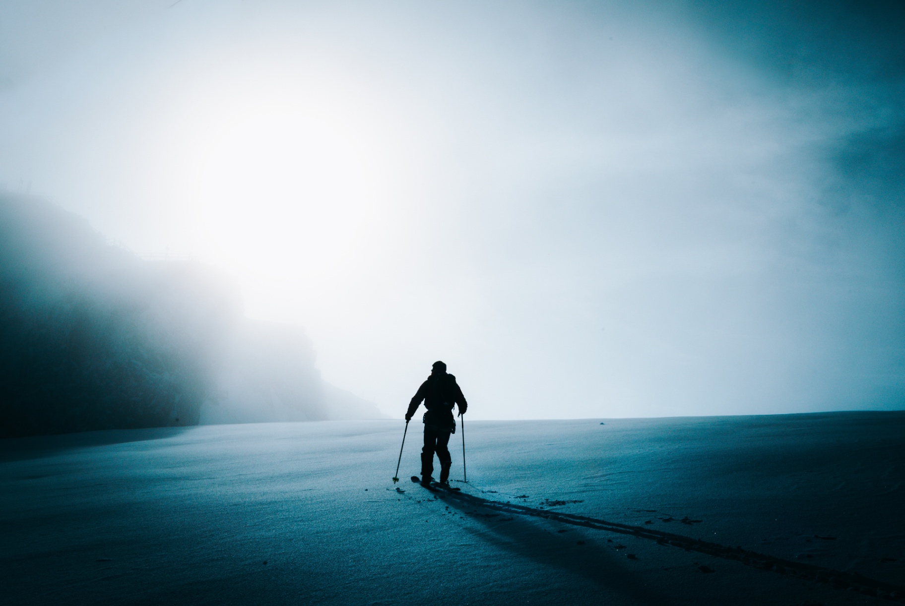 Lone ski tourer in glowing fog