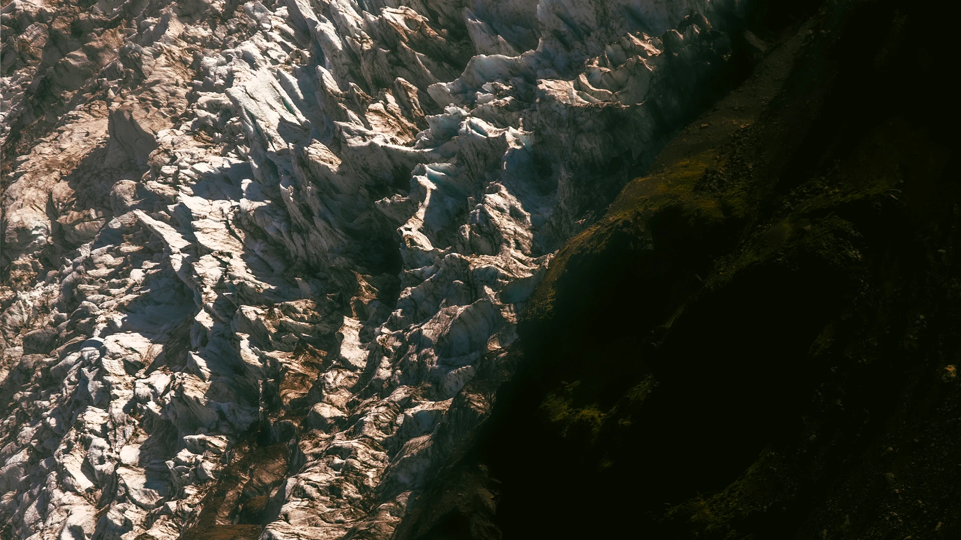 Abstract contrast between a sunlit glacier and a dark mountainside — fine art prints for your home