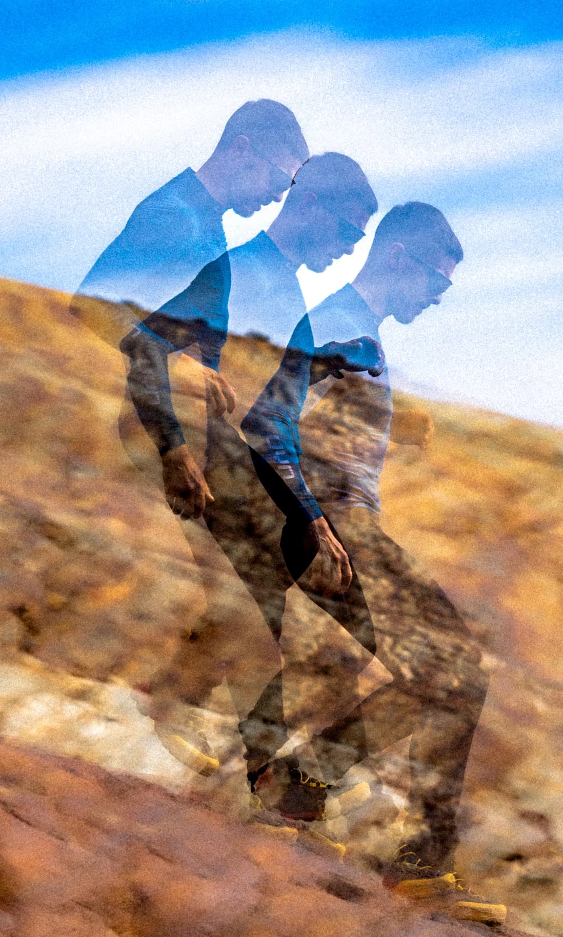Double exposure of a climber walking over golden rock against a blue sky