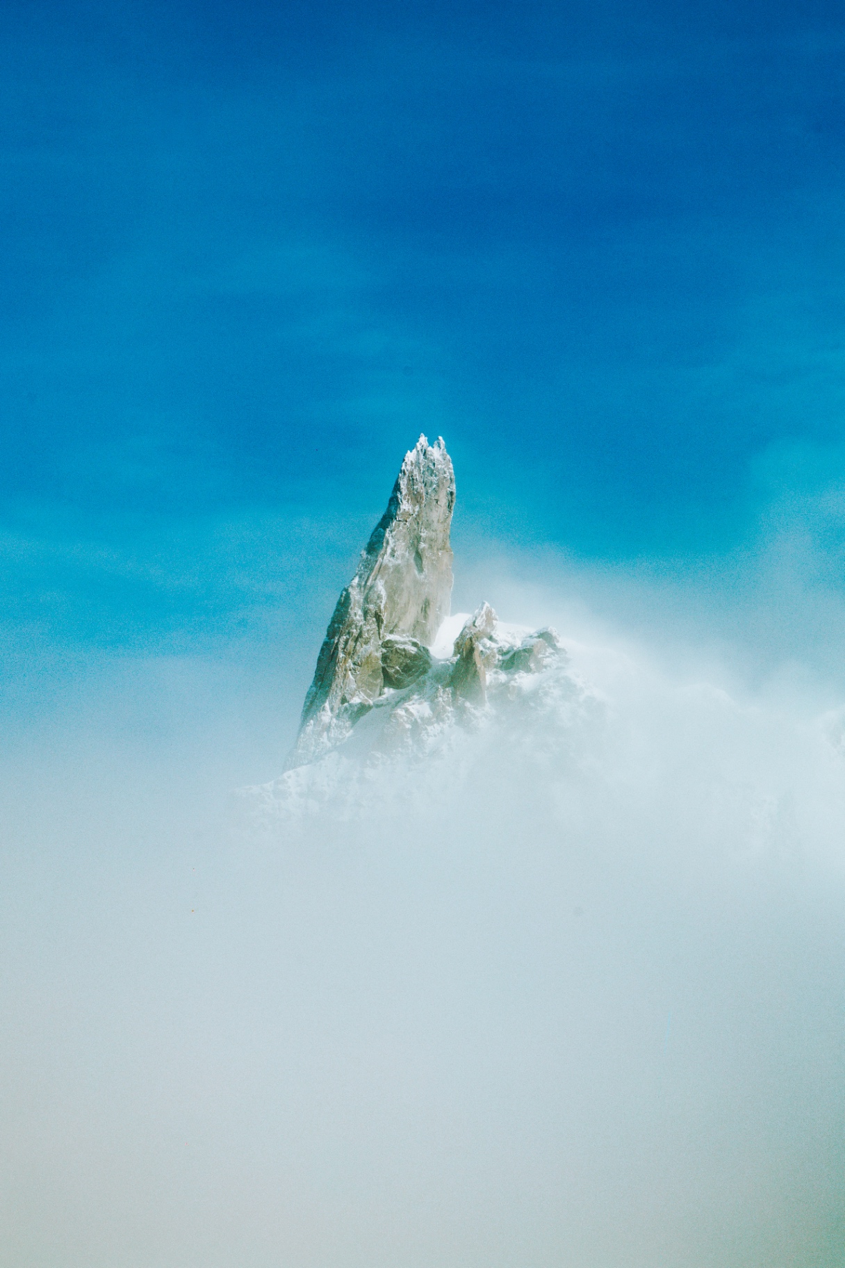 Rocky summit emerging from a sea of clouds