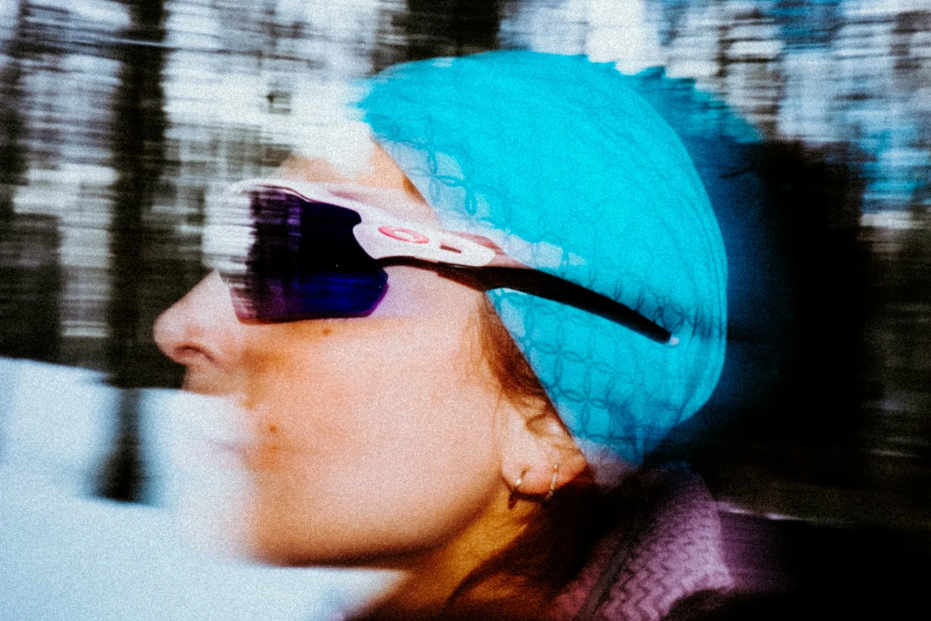 Close-up profile of a skier with turquoise beanie and reflective goggles