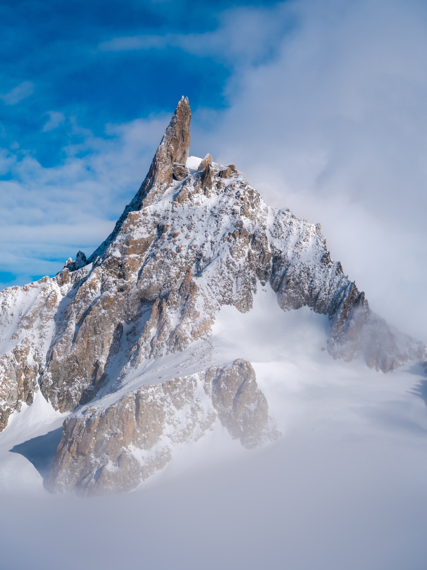 Snow-covered Dent du Géant among the clouds