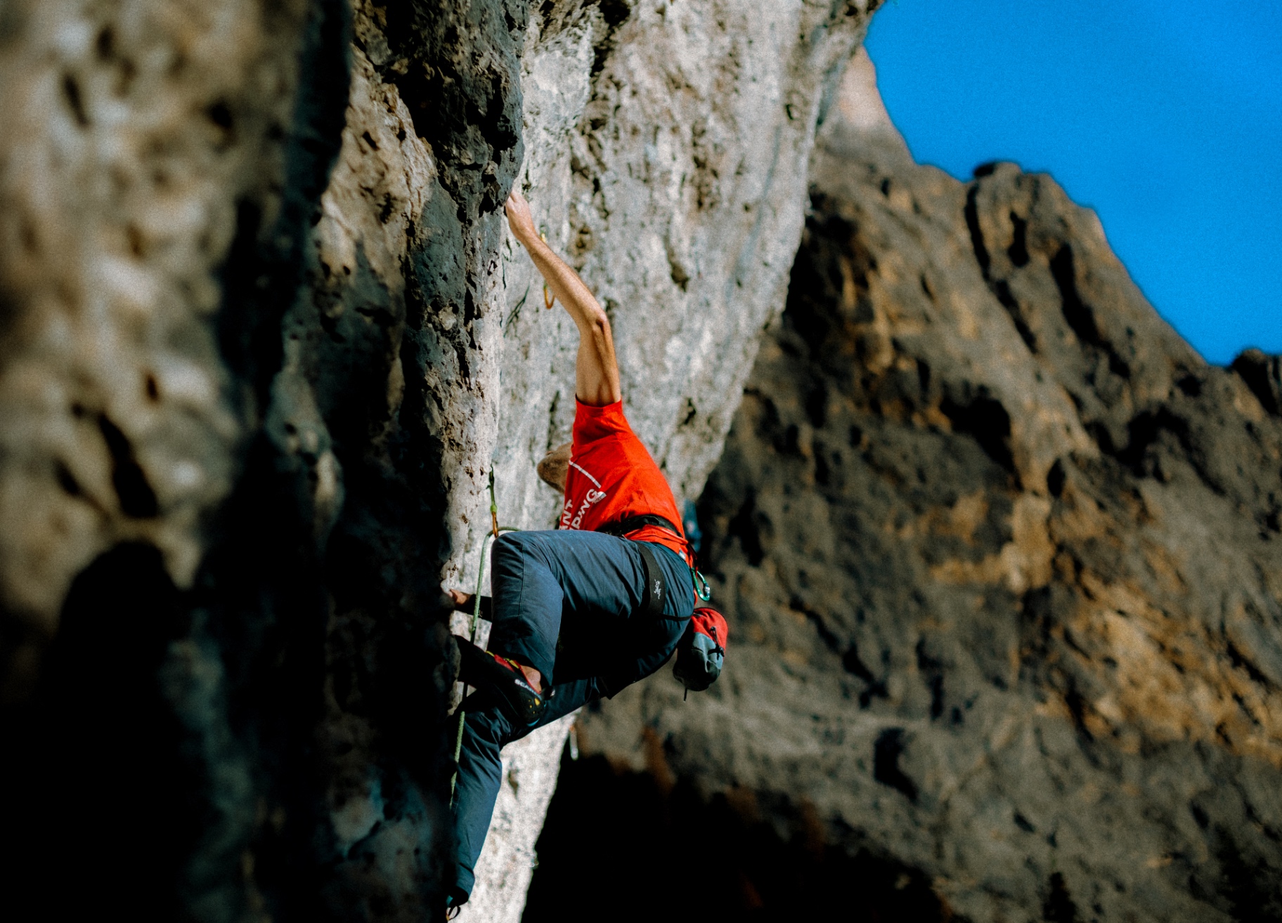 Climber in a red jersey on a limestone wall