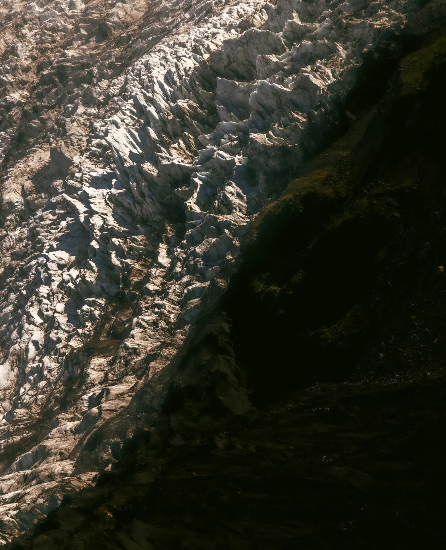 Sunlight and shadow across a deeply crevassed glacier