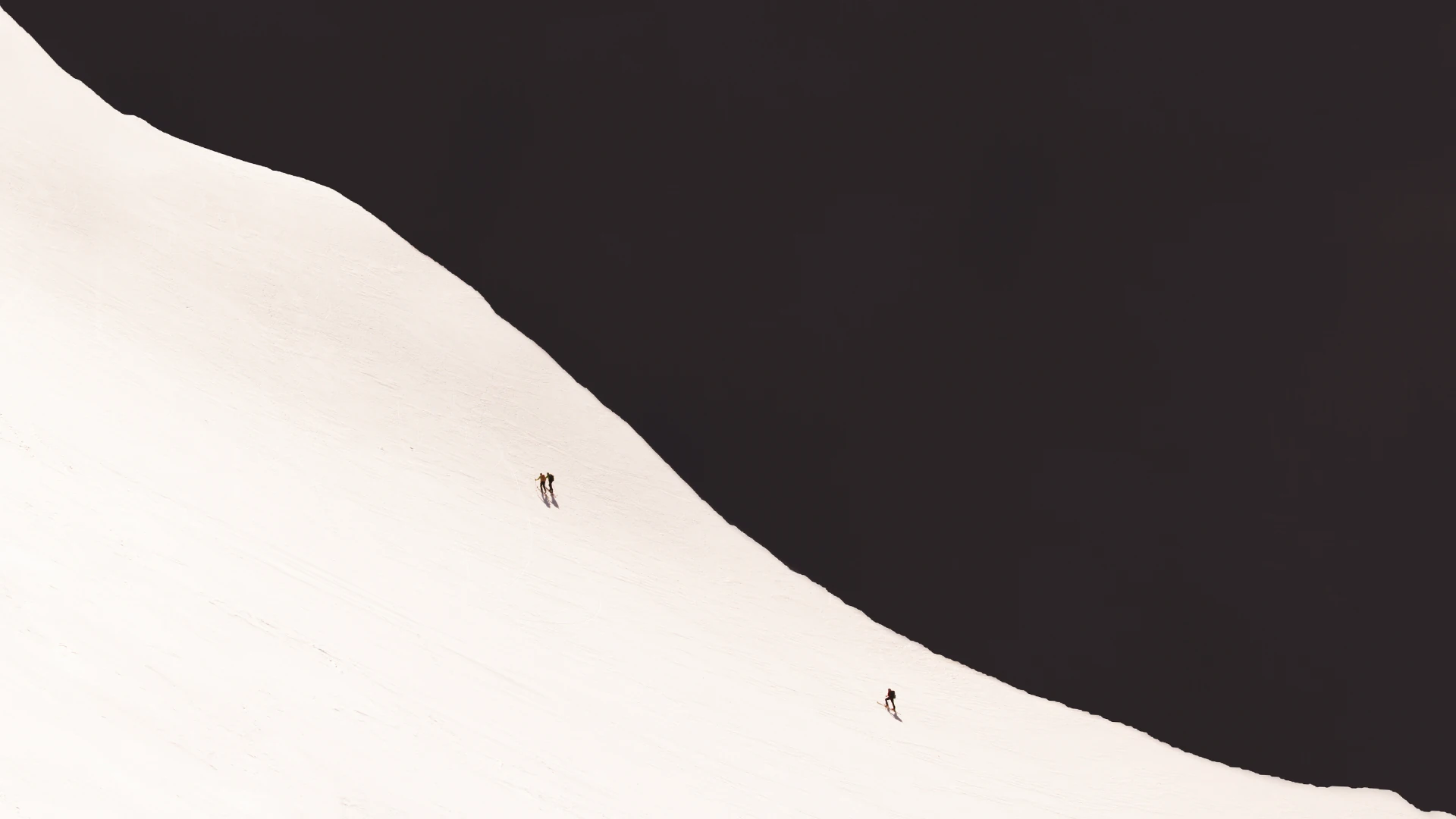 Three mountaineers crossing the curve of a vast snowy slope — fine art prints for your home