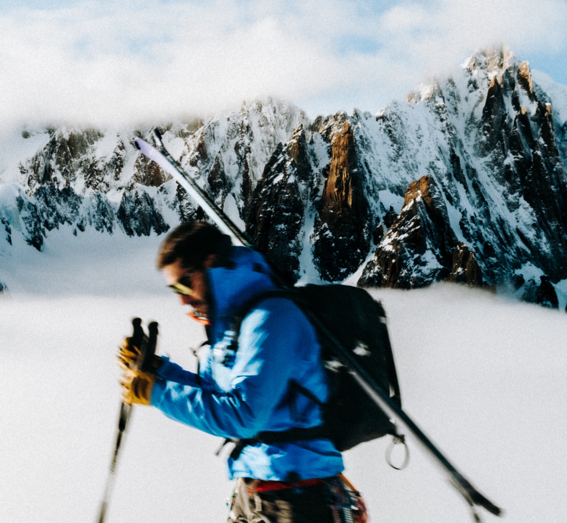 Ski tourer climbing in front of the Mont Blanc aiguilles